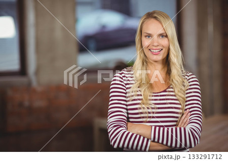 Woman wearing shirt smiling with folded arms in brick loft with industrial windows, copy space Woman wearing shirt smiling with folded arms in brick loft with industrial windows, copy space 133291712