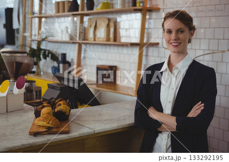 Female staff in blazer organizing pastries on marble counter at cafe using POS terminal, copy space 133292195