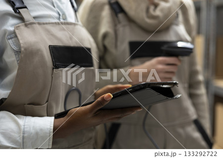 Bar code scanning for logistics handled by group of workers who oversee inventory management, product distribution and crate stacking for efficient delivery. Import export packages. 133292722