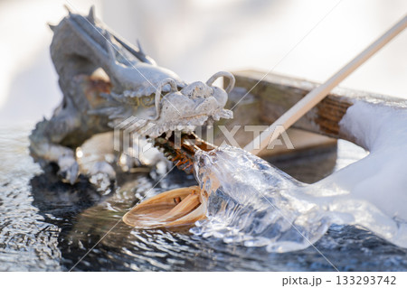 北海道音更町の厳冬期、朝日に照らされた氷結した手水舎の龍と柄杓の美しい冬の風景 133293742