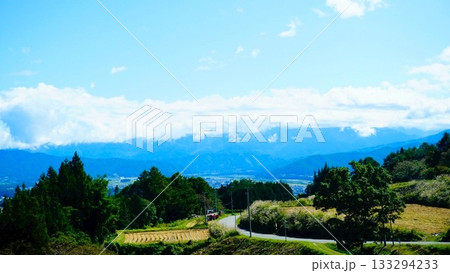黄金色に輝く稲穂と山の景色 黄金色に輝く稲穂と山の景色 133294233