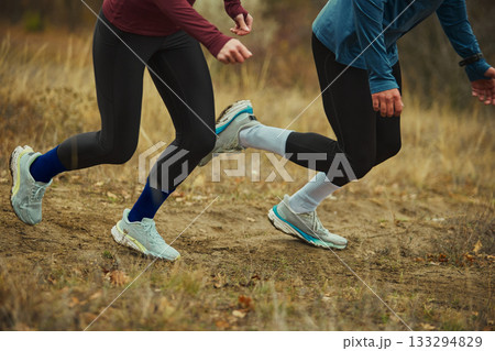 Close-up of runners legs on forest trail showing dynamic stride and power Close-up of runners legs on forest trail showing dynamic stride and power 133294829