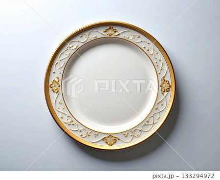 Fine dining. Ceramic plate with a classic white and gold design on a white background. Porcelain kitchenware. Close-up. Top view. Fine dining. Ceramic plate with a classic white and gold design on a white background. Porcelain kitchenware. Close-up. Top view. 133294972