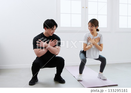 パーソナルトレーナーにトレーニングを受ける若い女性 133295181