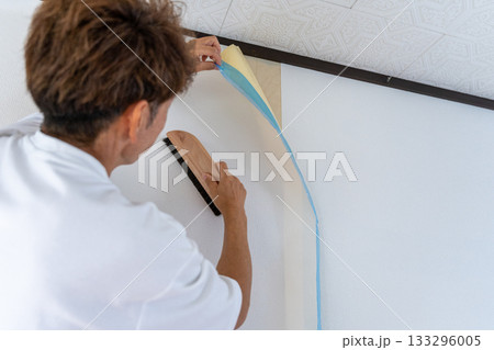 壁紙の張替えを丁寧に作業する男性 133296005