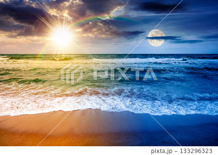 sea waves crashing sandy beach. day and night time change concept. summer solstice on a windy weather under cloudy sky with sun and moon. view of dramatic seascape. duality and transition template 133296323