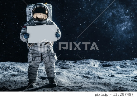 Astronaut Holding Blank Sign on Lunar Surface with Stars in Background 133297487