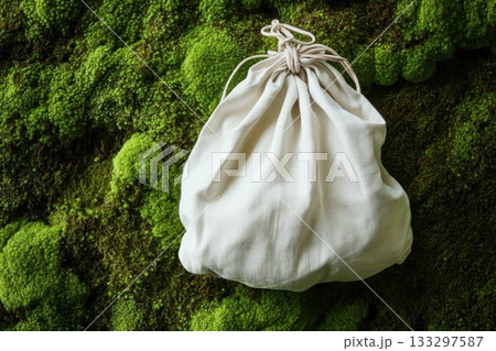 A white bag is sitting on a mossy green background A white bag is sitting on a mossy green background 133297587