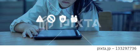 Soft blue light reflects on the tablet as the child taps the screen while safety icons appear above concerns about online risks and the need for careful guidance. Soft blue light reflects on the tablet as the child taps the screen while safety icons appear above concerns about online risks and the need for careful guidance. 133297736