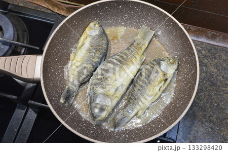 cooking freshwater fish crucian carp in a frying pan cooking freshwater fish crucian carp in a frying pan 133298420