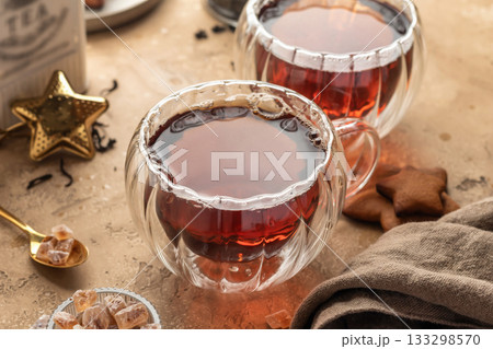 Black tea in two transparent glass cups on brown textured table background. Cozy breakfast teatime Black tea in two transparent glass cups on brown textured table background. Cozy breakfast teatime 133298570
