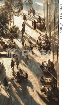 Modern office workers enjoy coffee break on sunny wooden terrace with natural light streaming through glass walls creating dramatic shadows Modern office workers enjoy coffee break on sunny wooden terrace with natural light streaming through glass walls creating dramatic shadows 133299671