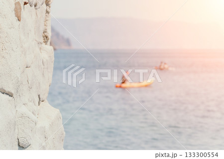 Kayaking, Coast, Sunset - Kayaking in the ocean near a rocky coast at sunset. Kayaking, Coast, Sunset - Kayaking in the ocean near a rocky coast at sunset. 133300554