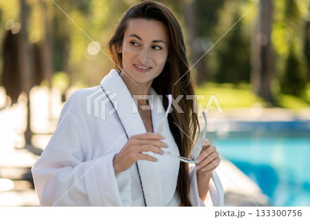 Beautiful young woman in white bath robe feeling enjoyed and confident Beautiful young woman in white bath robe feeling enjoyed and confident 133300756