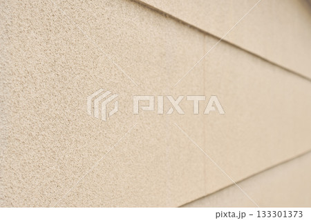 リシン仕上げによる凸凹のある黄土色の外壁の背景テクスチャー	 133301373