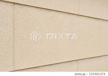 リシン仕上げによる凸凹のある黄土色の外壁の背景テクスチャー	 133301374