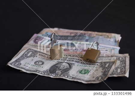 stack of international currency bills secured with padlocks on black stack of international currency bills secured with padlocks on black 133301496