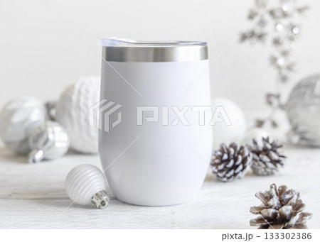 White blank Stainless Steel wine tumbler near Christmas baubles and decor on table, mockup 133302386