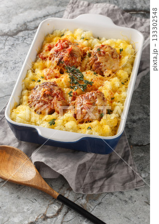 Meatball casserole with mashed potatoes, cheese, tomato sauce, and thyme in a baking dish. Vertical Meatball casserole with mashed potatoes, cheese, tomato sauce, and thyme in a baking dish. Vertical 133302548