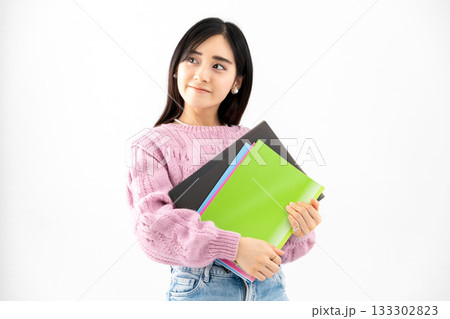ノートやファイルを持って立っている若い女性 ノートやファイルを持って立っている若い女性 133302823