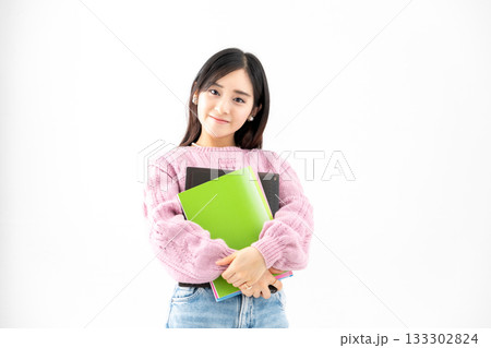 ノートやファイルを持って立っている若い女性 133302824