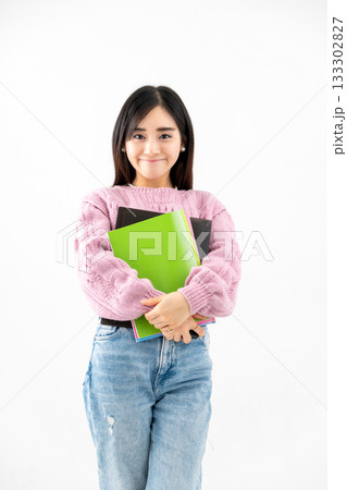 ノートやファイルを持って立っている若い女性 ノートやファイルを持って立っている若い女性 133302827