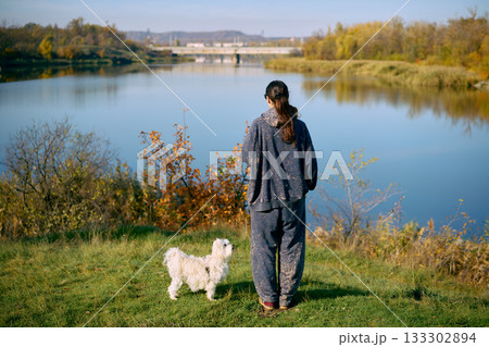 Back view of young woman relax and enjoy serene lake and autumn landscape Back view of young woman relax and enjoy serene lake and autumn landscape 133302894