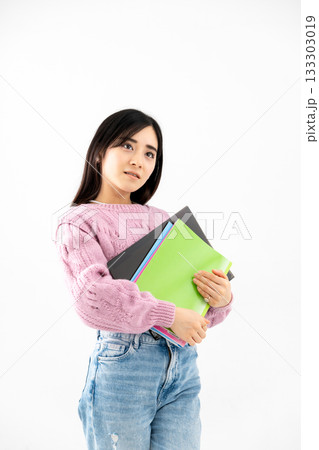 ノートやファイルを持って立っている若い女性 ノートやファイルを持って立っている若い女性 133303019
