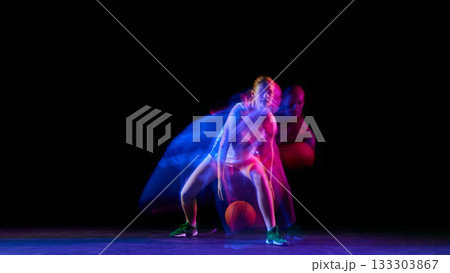 Basketball player dribbling low in colorful motion blur lighting. 133303867