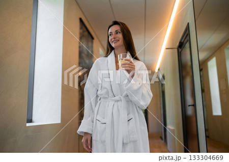 Cute young woman in white bath robe feeling comfortable and relaxed Cute young woman in white bath robe feeling comfortable and relaxed 133304669