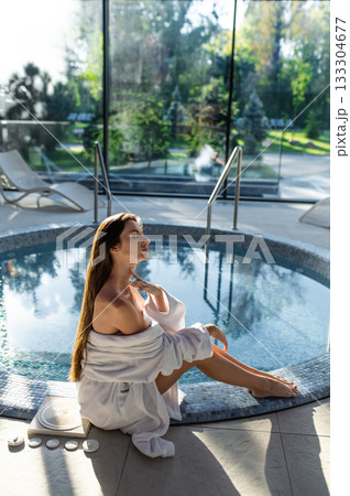 Long-haired young woman in white at the swimming pool in spa center Long-haired young woman in white at the swimming pool in spa center 133304677
