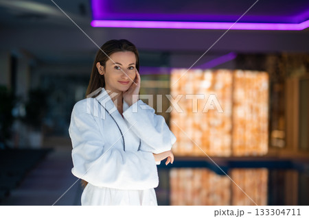 Long-haired pretty woman in white bath robe feeling relaxed 133304711