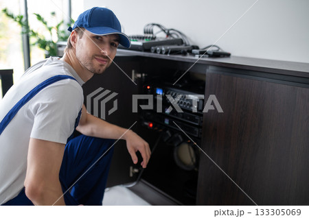 Audio engineer setting up speakers in office Audio engineer setting up speakers in office 133305069