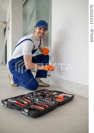 Skilled craftsman fixing electrical outlet 133305076