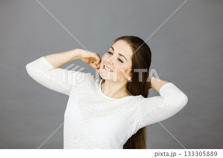 Happy woman brushing her hair 133305889