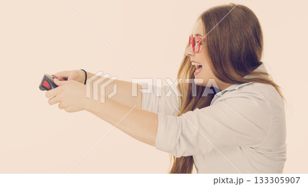 Profile view of woman playing video games Profile view of woman playing video games 133305907