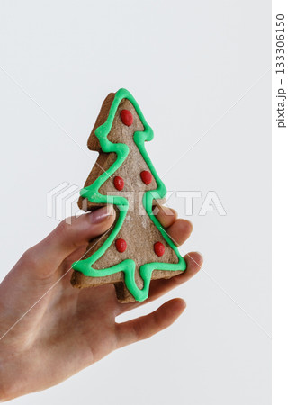 Hand holds christmas tree made of sweet gingerbread cookie. Hand holds christmas tree made of sweet gingerbread cookie. 133306150