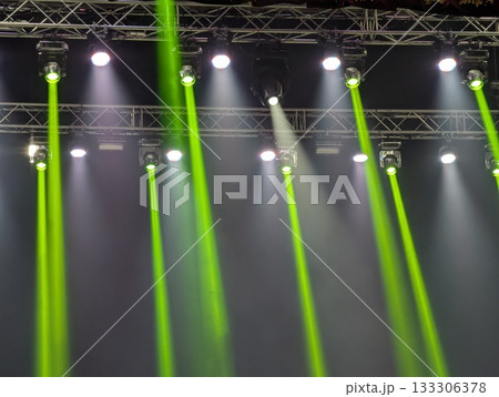 Multicolored beams of stage lighting illuminate the stage of the hall before the performance 133306378