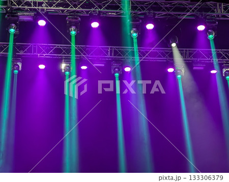 Multicolored beams of stage lighting illuminate the stage of the hall before the performance 133306379