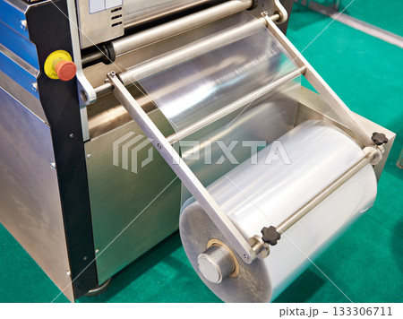 Roll of packaging film on machine food factory Roll of packaging film on machine food factory 133306711