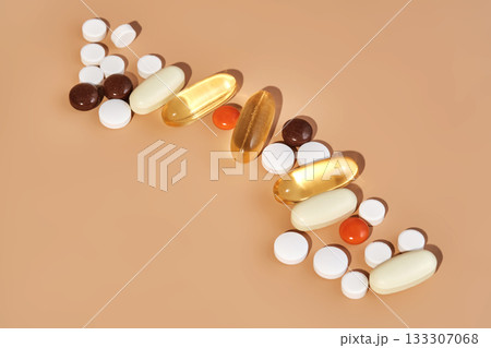 Pills and supplements in a row on beige background Pills and supplements in a row on beige background 133307068