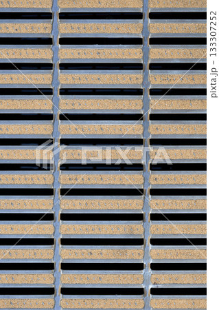 デザイン性のある金属製グレーチングのクローズアップ。格子状の側溝の蓋と規則的なパターン 133307252