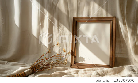 Wooden photo frame with dried flower in soft sunlight 133307970