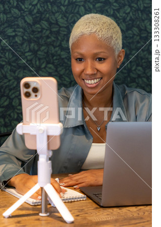 African American woman smiles at camera of her phone. female blogger records video. 133308261