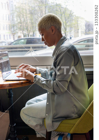 work online. African American young woman is sitting in coffee shop and working on laptop. 133308262