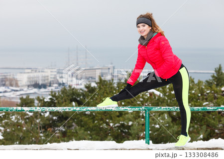 Woman wearing sportswear exercising during winter 133308486