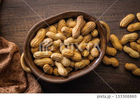 Peanuts in shell. Groundnuts in bowl on wooden table. Top view. Peanuts in shell. Groundnuts in bowl on wooden table. Top view. 133308860