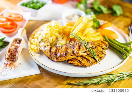 Fried Wiener schnitzel from veal topside with French fries as top view on a modern design plate with copy space Fried Wiener schnitzel from veal topside with French fries as top view on a modern design plate with copy space 133308930