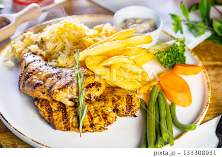 Fried Wiener schnitzel from veal topside with French fries as top view on a modern design plate with copy space Fried Wiener schnitzel from veal topside with French fries as top view on a modern design plate with copy space 133308931