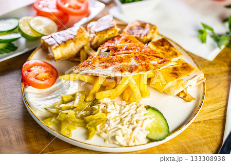 Chicken roll breast stuffed with butter, garlic and dill. Served with baked potato slices and fresh herbs. 133308938